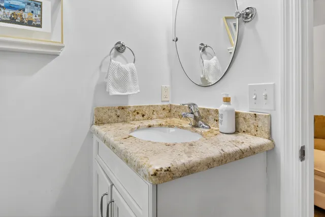 a bathroom with a granite countertop sink and a mirror