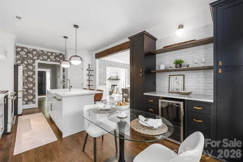 a kitchen with a stove a chandelier and wooden floor