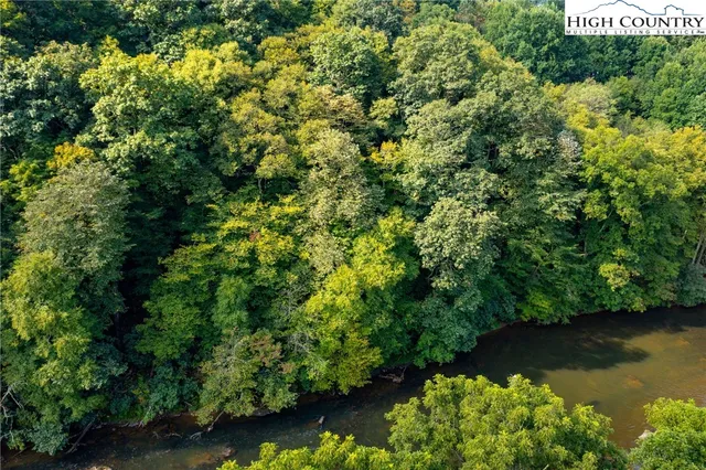 an aerial view of residential house with outdoor space and trees all around