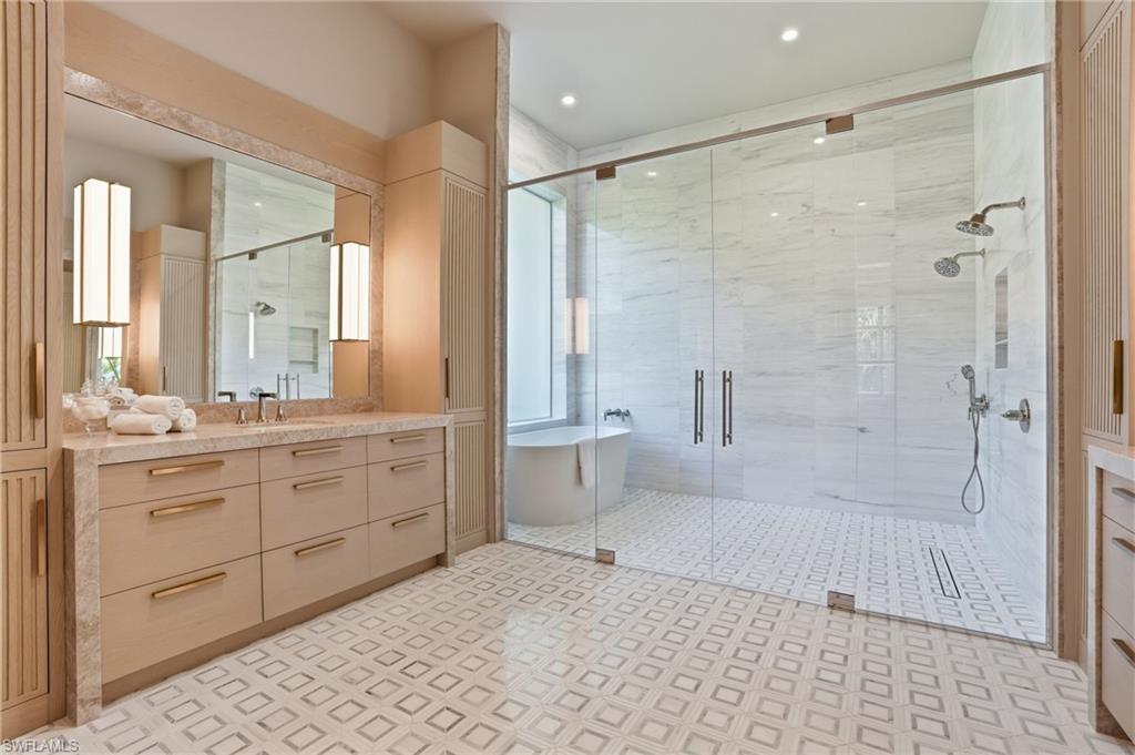 4851 Crayton Road Naples, FL 34103 - Photo 18 of 33 a bathroom with a granite countertop sink a toilet a mirror and shower