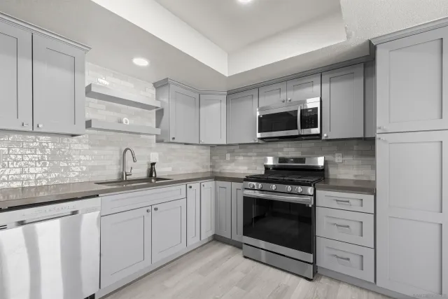 a kitchen with white cabinets and stainless steel appliances