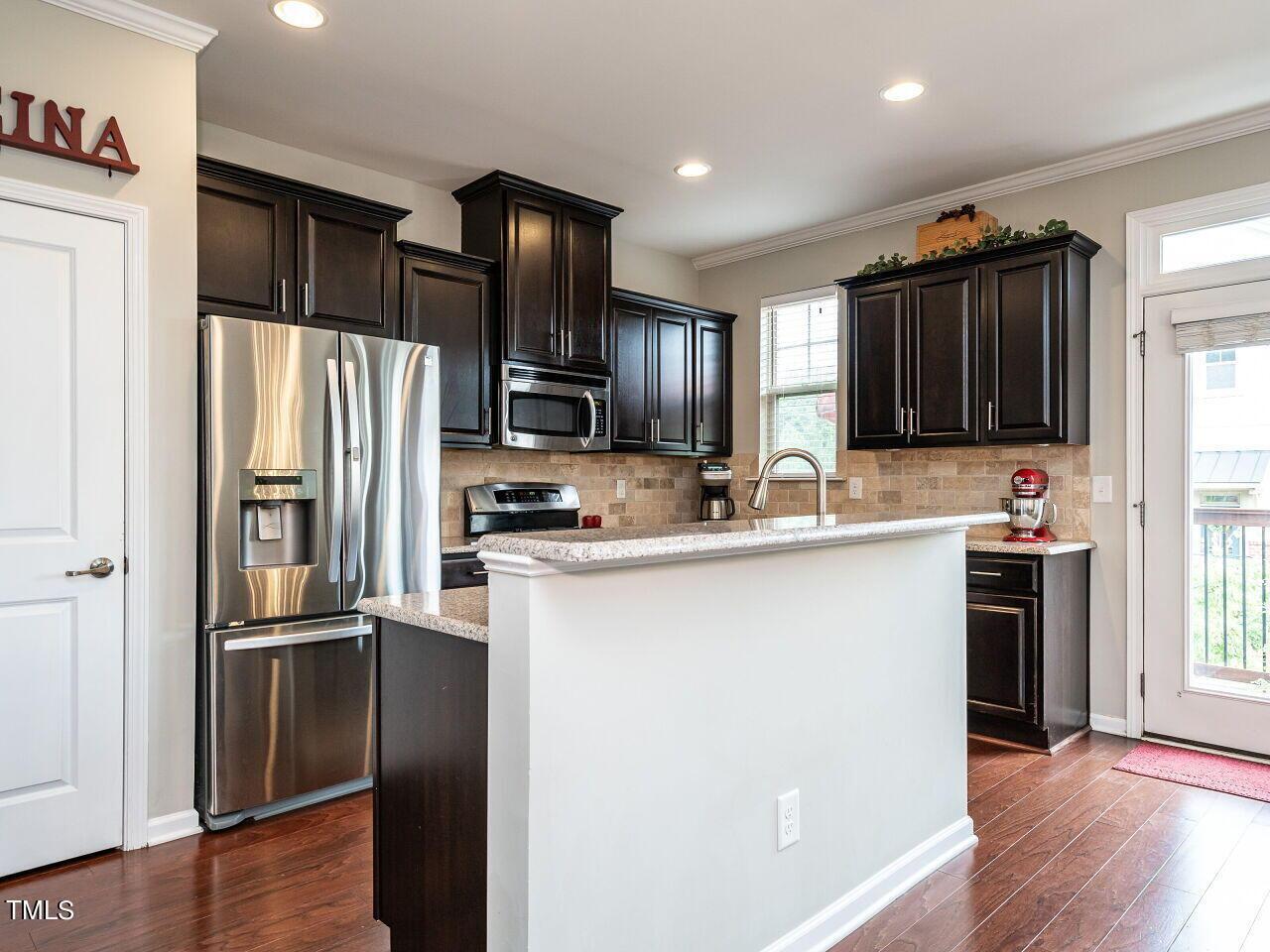 1316 Cornell Place Raleigh, NC 27607 - Photo 6 of 31 a kitchen with kitchen island granite countertop stainless steel appliances and refrigerator