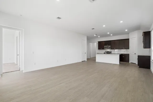 a view of kitchen with microwave oven a stove and white cabinets