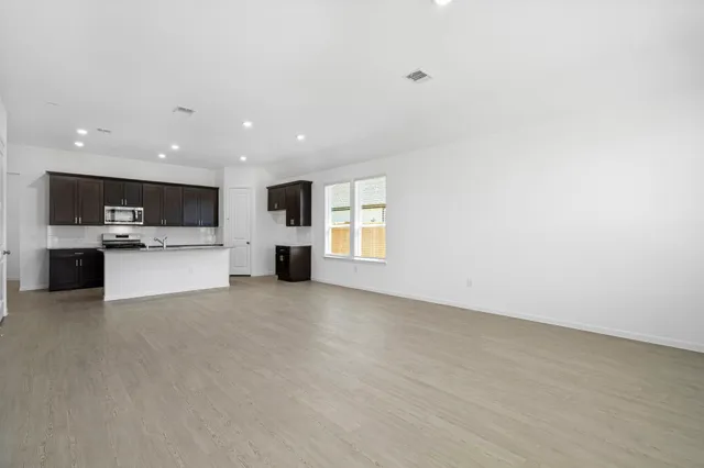 a view of an empty room with a kitchen