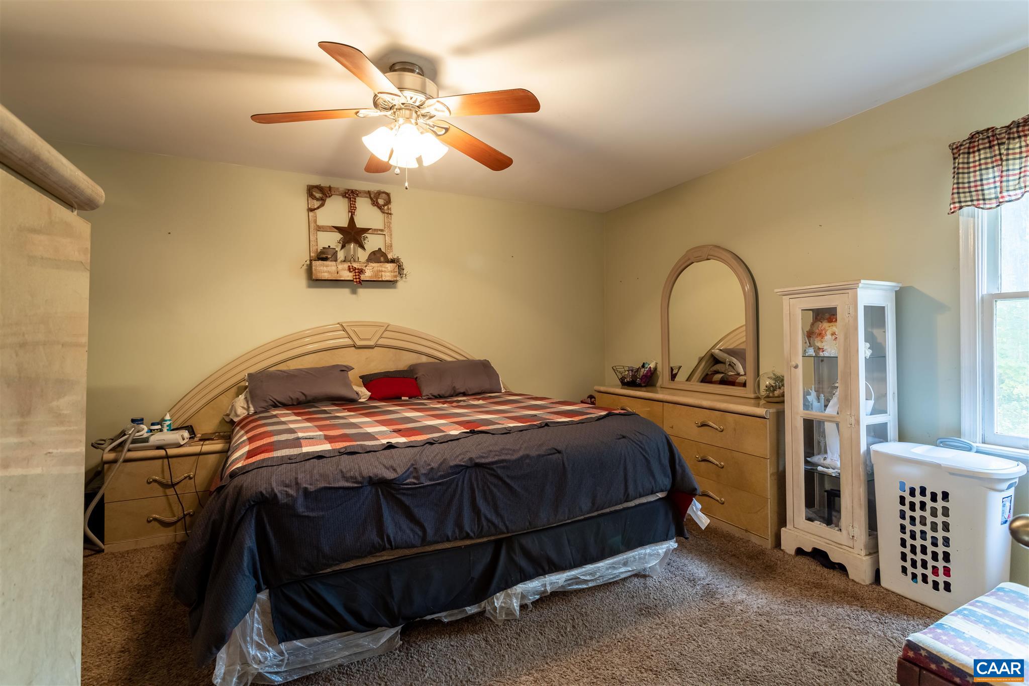 2588 South Blue Ridge Turnpike Rochelle, VA 22738 - Photo 13 of 30 a bedroom with a bed and a chandelier