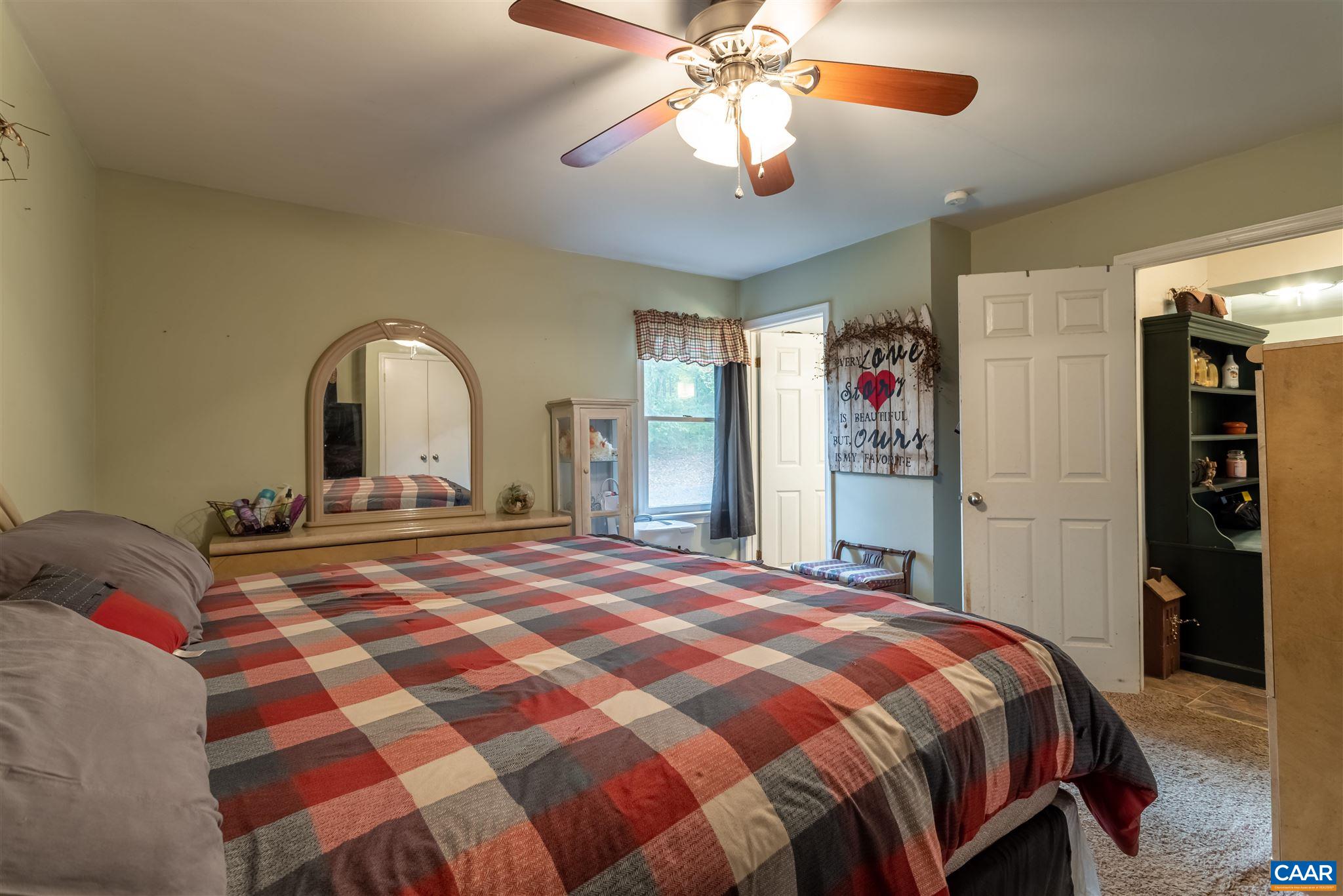 2588 South Blue Ridge Turnpike Rochelle, VA 22738 - Photo 14 of 30 a bedroom with a large bed and a chandelier