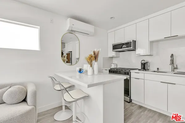 a kitchen with stainless steel appliances granite countertop a sink a stove top oven a counter space and cabinets