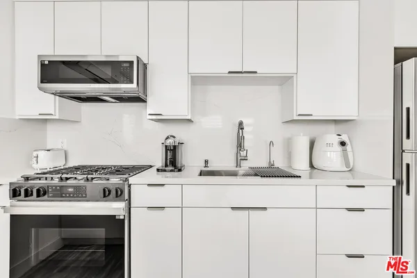 a kitchen with stainless steel appliances granite countertop a sink stove and microwave