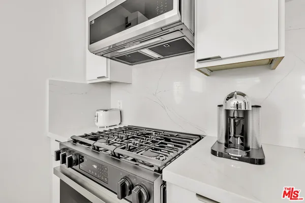 a stove top oven sitting inside of a kitchen