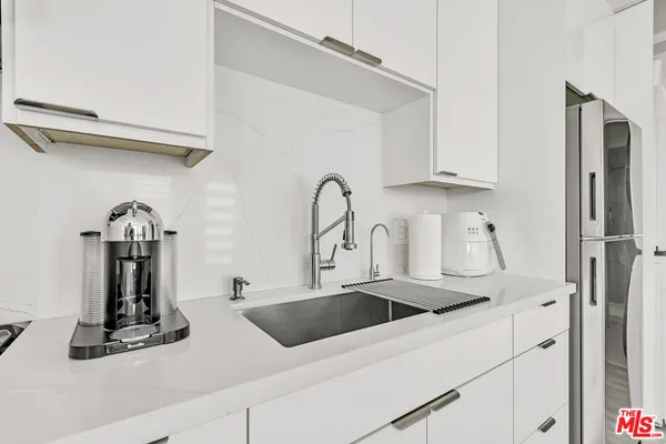 a kitchen with a refrigerator sink and cabinets