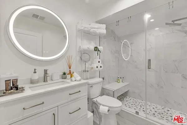 a bathroom with a sink a toilet and shower