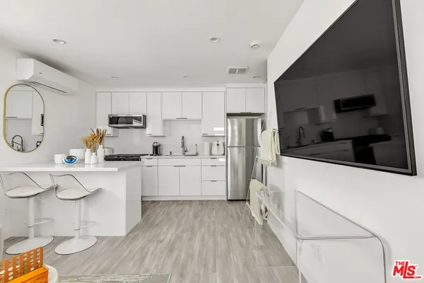 a kitchen with white cabinets and white appliances