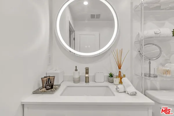 a bathroom with a toilet sink vanity and mirror