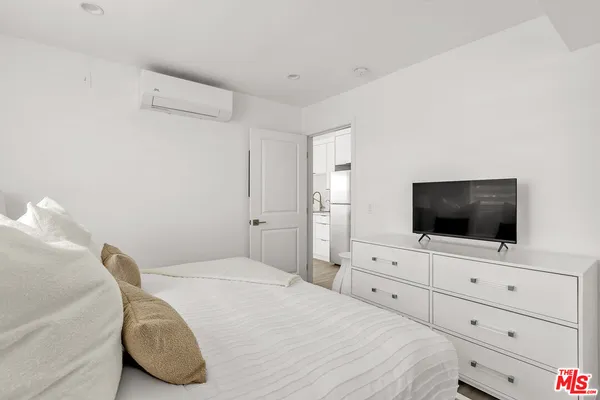 a bedroom with a bed and flat screen tv