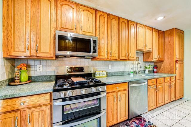 74 Briar Avenue Edison, NJ 08817 - Photo 15 of 30 a kitchen with stainless steel appliances granite countertop a stove a sink and a microwave