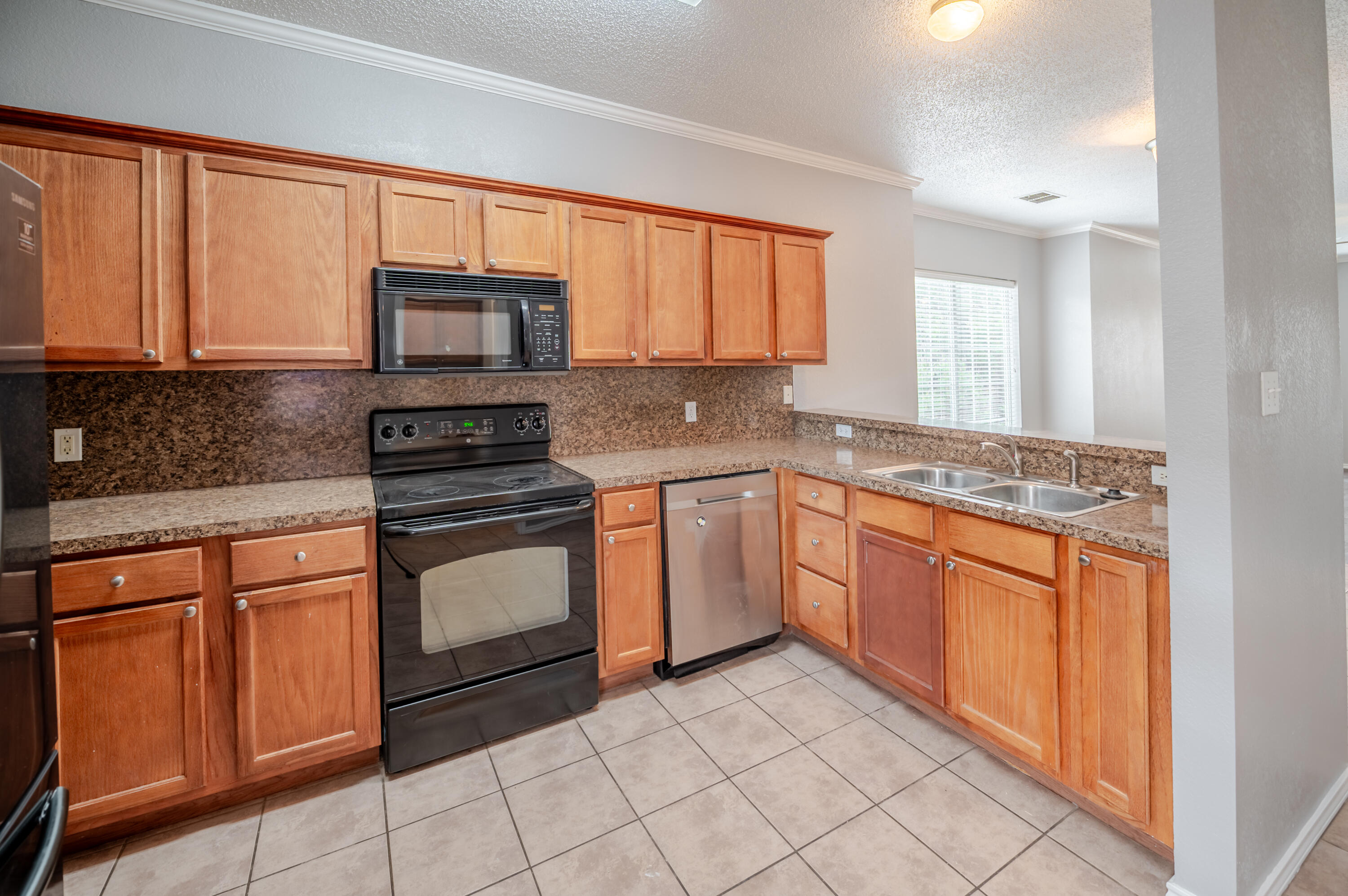2111 Main Street, Unit 1 Lubbock, TX 79401 - Photo 5 of 36 a kitchen with stainless steel appliances granite countertop a stove sink microwave and cabinets