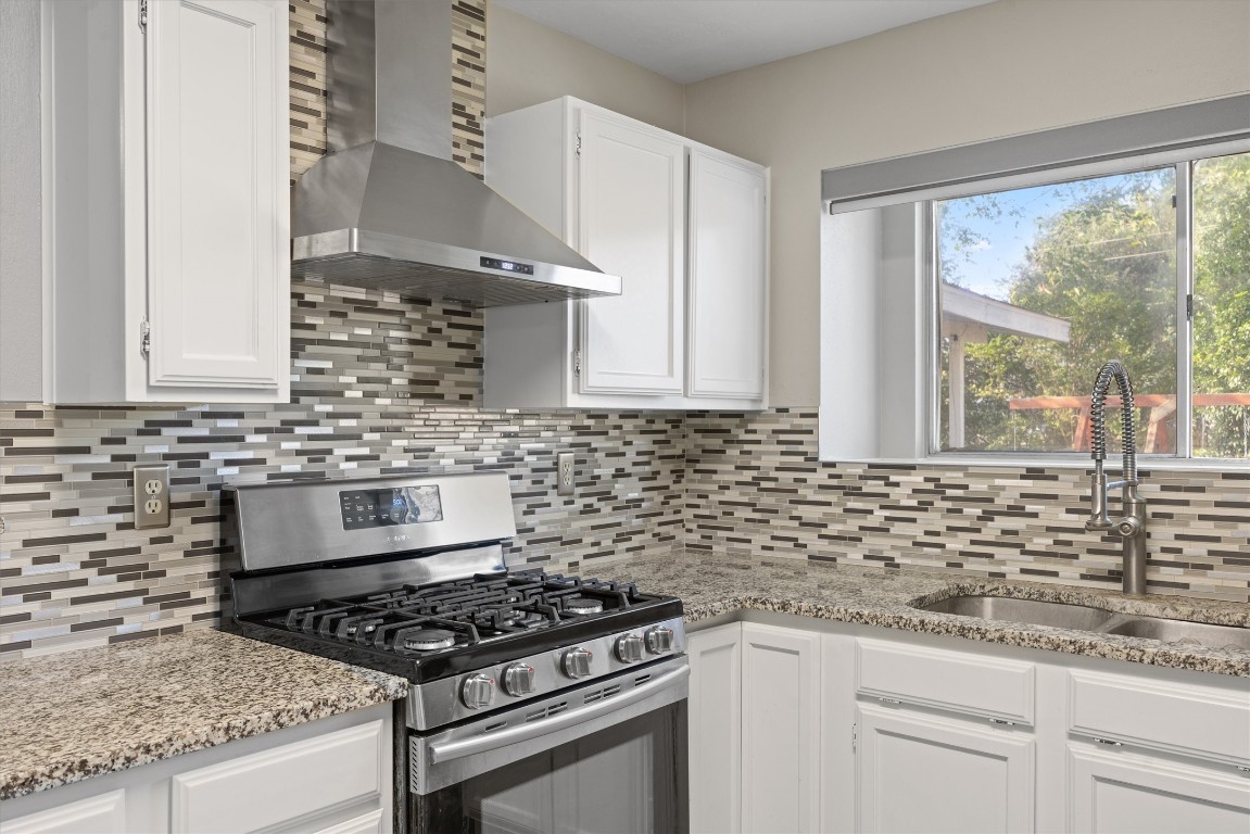 1511 Quail Run Road Pflugerville, TX 78660 - Photo 12 of 27 a kitchen with granite countertop a stove sink and cabinets