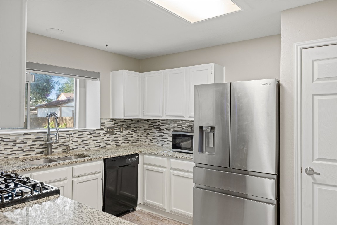 1511 Quail Run Road Pflugerville, TX 78660 - Photo 13 of 27 a kitchen with stainless steel appliances a refrigerator sink and cabinets