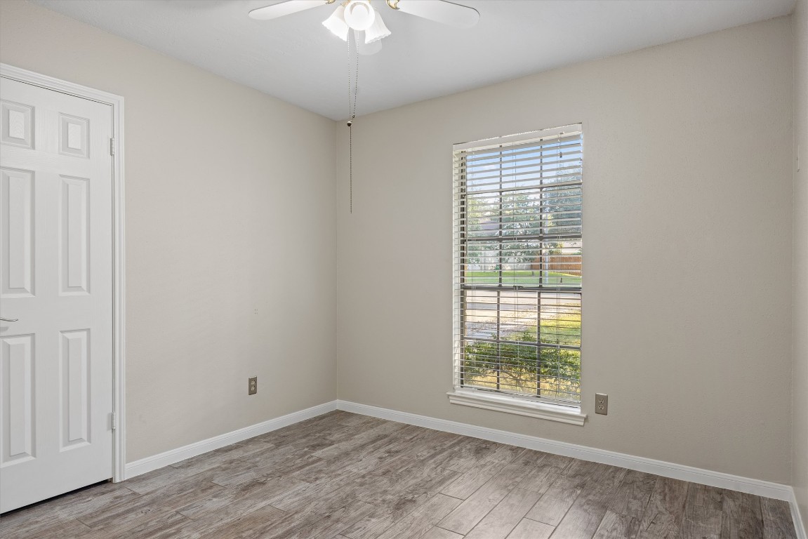 1511 Quail Run Road Pflugerville, TX 78660 - Photo 14 of 27 a view of an empty room with a window and wooden floor