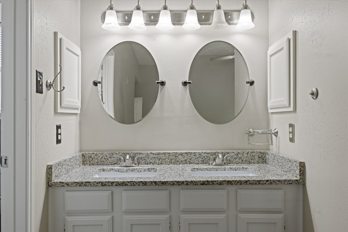 1511 Quail Run Road Pflugerville, TX 78660 - Photo 23 of 27 a bathroom with a granite countertop double vanity sink and mirror