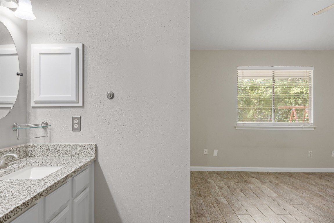 1511 Quail Run Road Pflugerville, TX 78660 - Photo 24 of 27 a bathroom with a granite countertop sink and a mirror