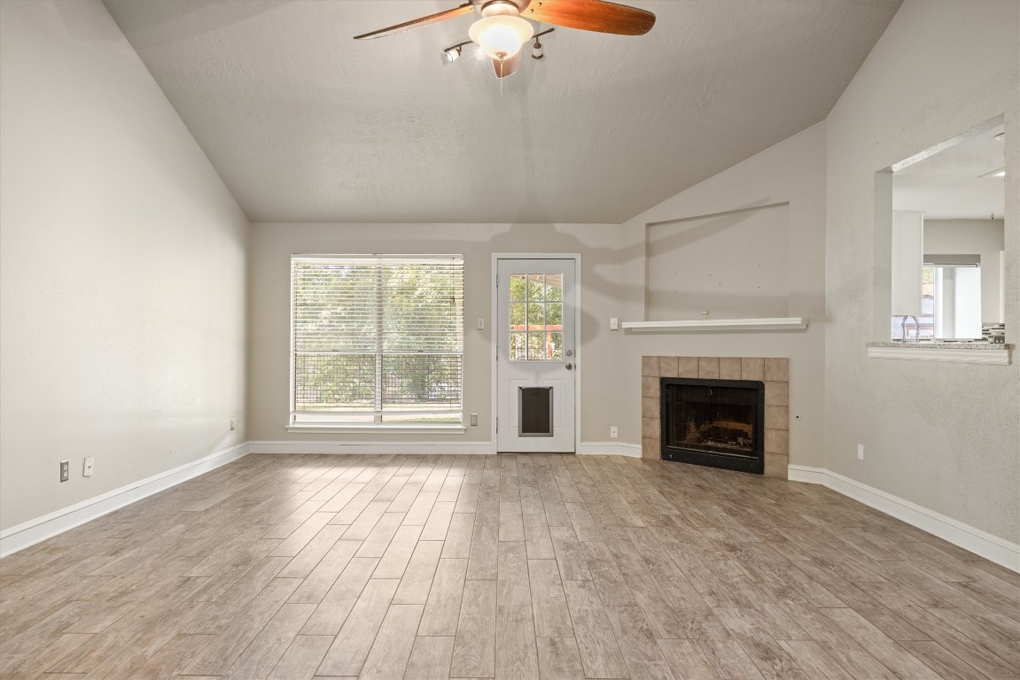 1511 Quail Run Road Pflugerville, TX 78660 - Photo 5 of 27 wooden floor fireplace and windows in an empty room