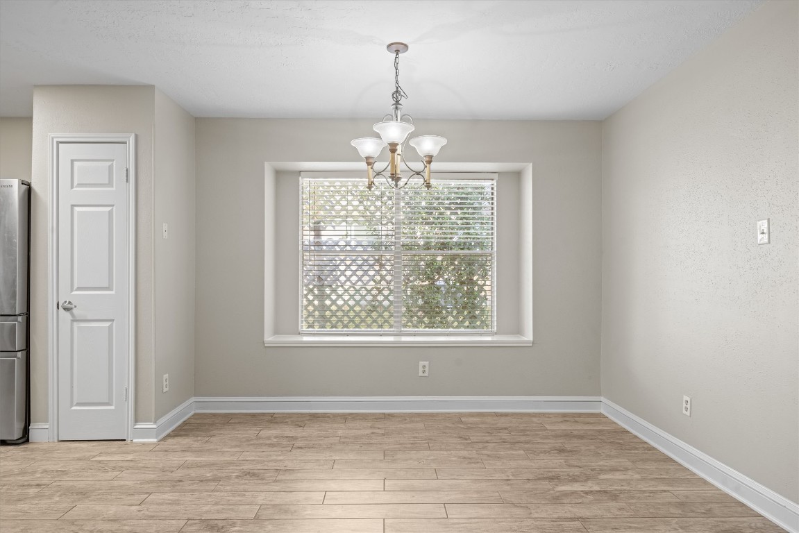 1511 Quail Run Road Pflugerville, TX 78660 - Photo 9 of 27 an empty room with chandelier fan and windows