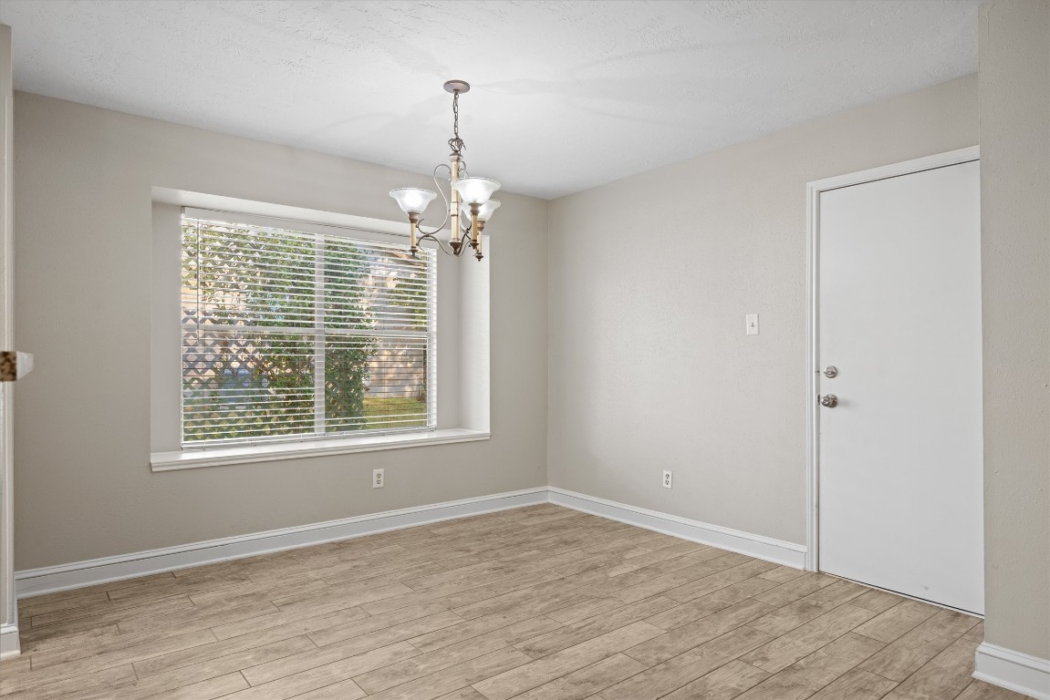 1511 Quail Run Road Pflugerville, TX 78660 - Photo 10 of 27 a view of an empty room with wooden floor and a window
