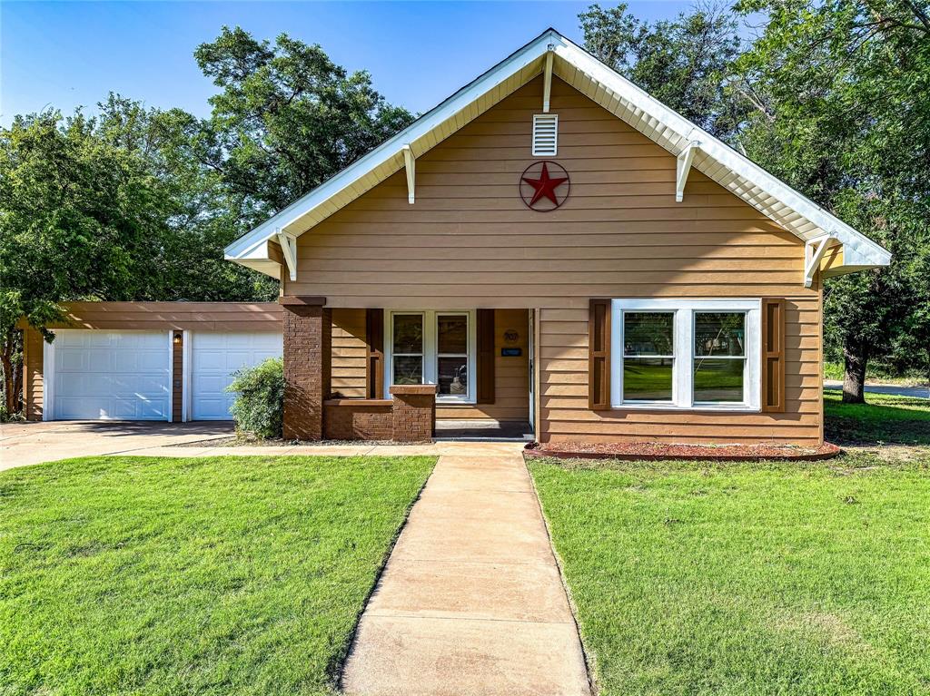 a front view of house with yard and green space
