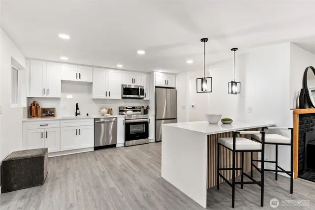 a kitchen with white cabinets and stainless steel appliances