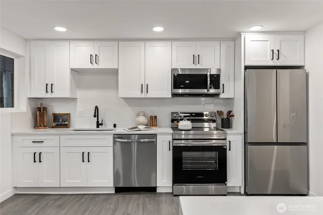 a kitchen with white cabinets and stainless steel appliances
