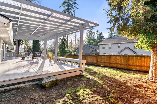a view of a backyard with a small pool and wooden fence