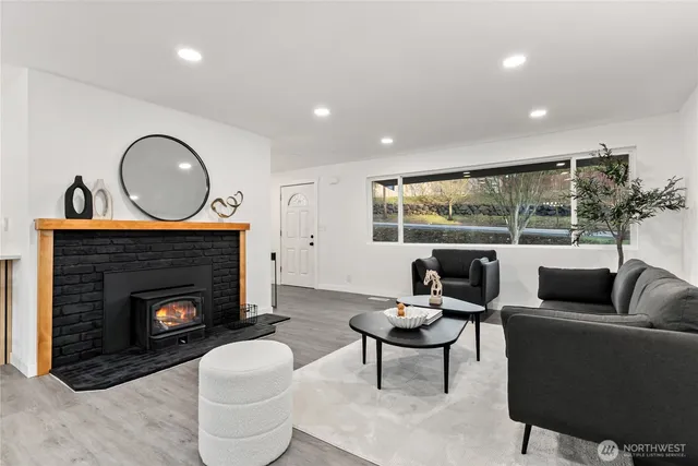 a living room with furniture a fireplace and a floor to ceiling window