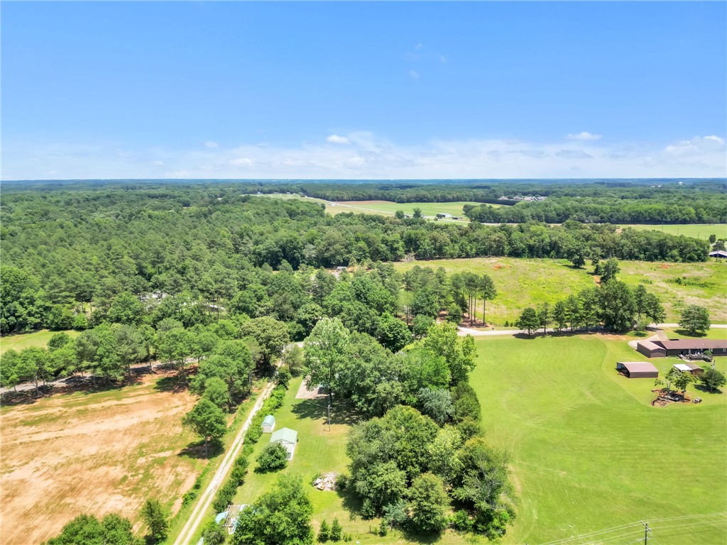 602 Harper Road Pendleton, SC 29670 - Photo 32 of 32 An aerial panorama reveals verdant fields and a sprawling wooded landscape under an endless blue sky.