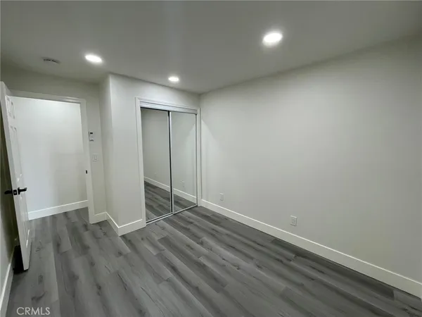 an empty room with wooden floor and closet