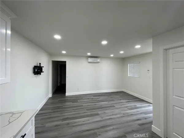 a view of an empty room with wooden floor