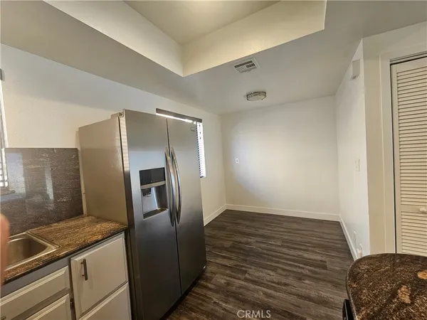 a kitchen with granite countertop a refrigerator and a sink