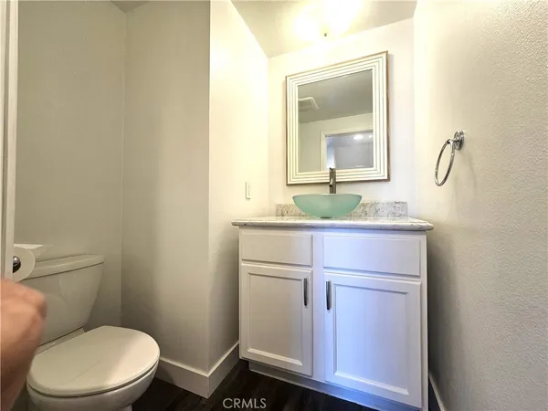 a bathroom with a granite countertop toilet sink and mirror