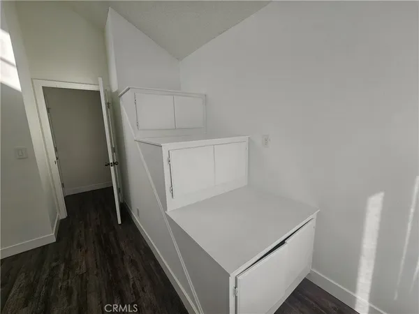 a storage room with wooden floor washer and dryer