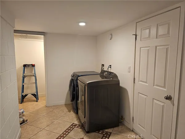 a view of a storage & utility room with two washing machine