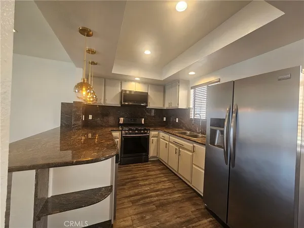 a kitchen with stainless steel appliances granite countertop a refrigerator and stove