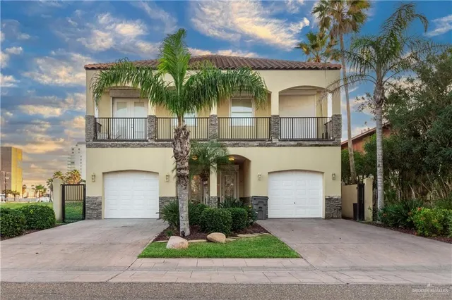 front view of house with a yard and palm trees