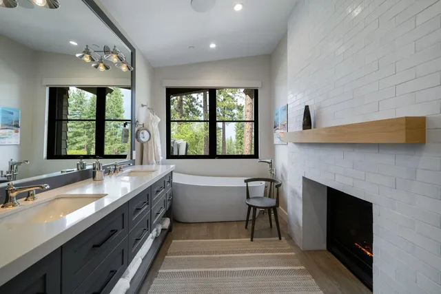 a spacious bathroom with a granite countertop sink a large mirror and a bathtub