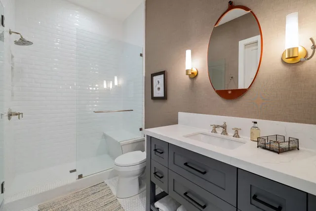 a bathroom with a toilet a sink and mirror