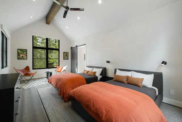 a bedroom with two beds and a large window