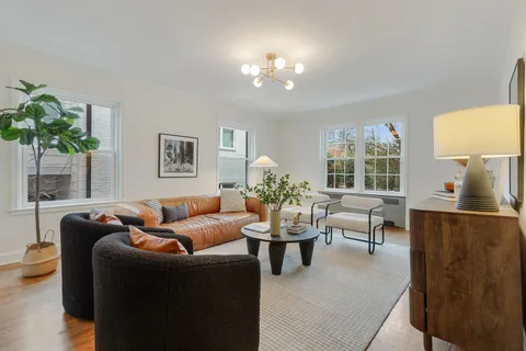 a living room with furniture a chandelier and a window
