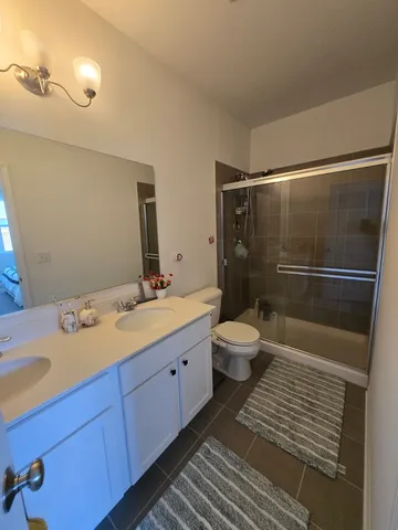 a bathroom with a double vanity sink toilet and shower