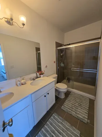 a bathroom with a double vanity sink toilet and shower