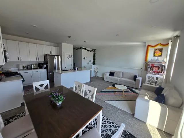 a living room with furniture rug and kitchen view