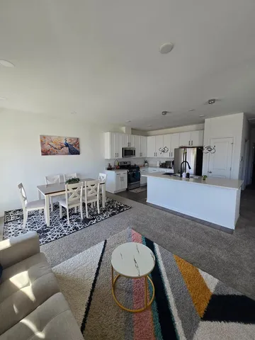 a living room with furniture and kitchen view